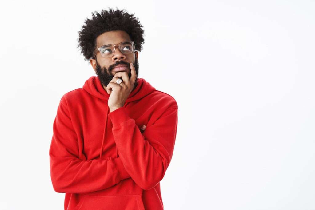 An african american bearded guy with afro hairstyle-glasses thinking